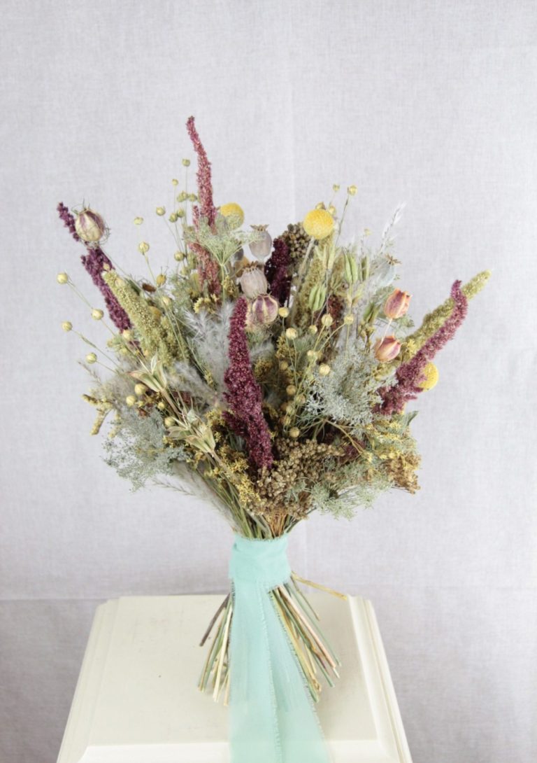 Weiße Blumenarrangement in einem Topf auf einem hellen Untergrund.