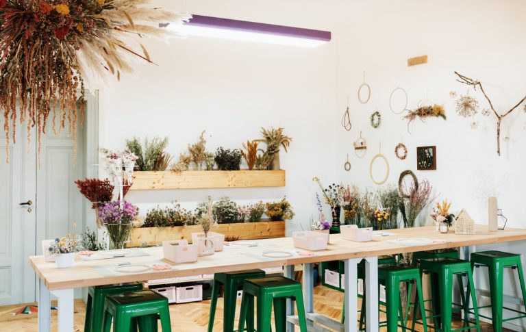 Eine große Werkbank mit rosa Körben und Werkzeug für einen Trockenblumen Workshop.