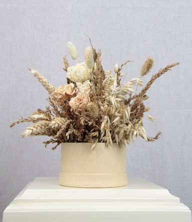 Trockenblumenstrauß in neutralem Topf, beige und braune Farbtöne.