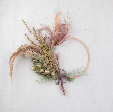 Floraler Kranz aus getrockneten Pflanzen in sanften Farben und zarten Texturen.
