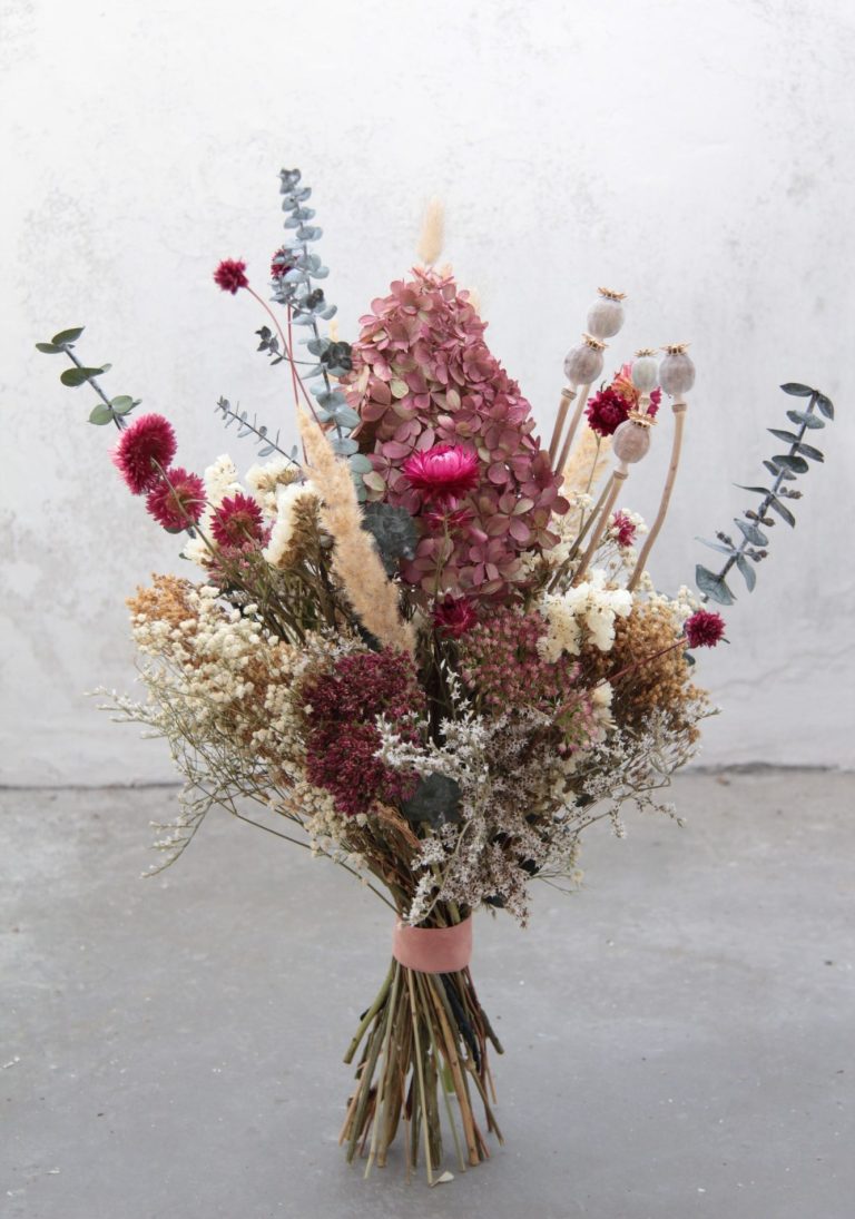 Blumenarrangement hängt von der Decke in einem bunten Verkaufsraum. Kunden erkunden Produkte.