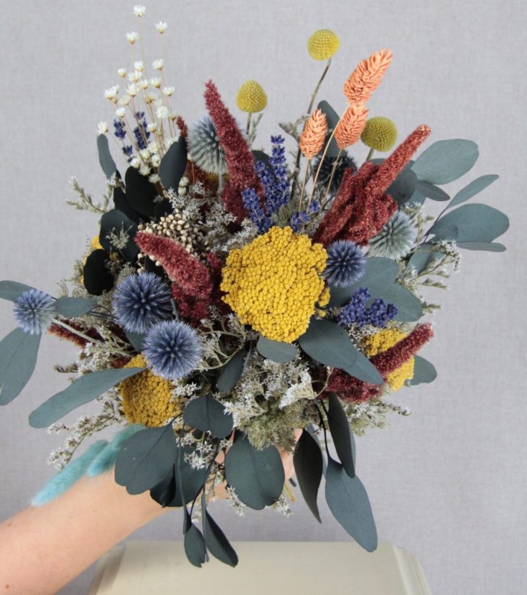 Kranz aus frischen Eukalyptus Blättern hängt an einem Roten Auto im Fenster.