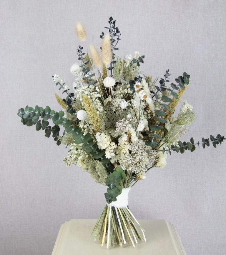 Kranz aus frischen Eukalyptus Blättern hängt an einem Roten Auto im Fenster.